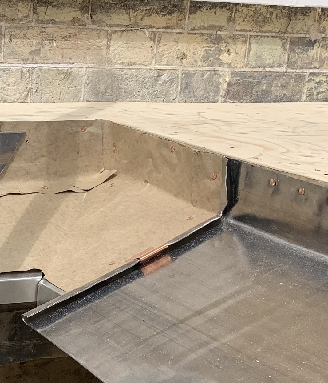Slip layer beneath lead roofing detail to reduce friction and support long term performance