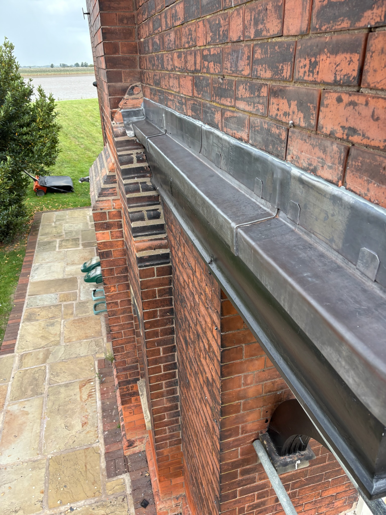 Lead flashing detail covering a timber and masonry plinth with a clipped perimeter edge