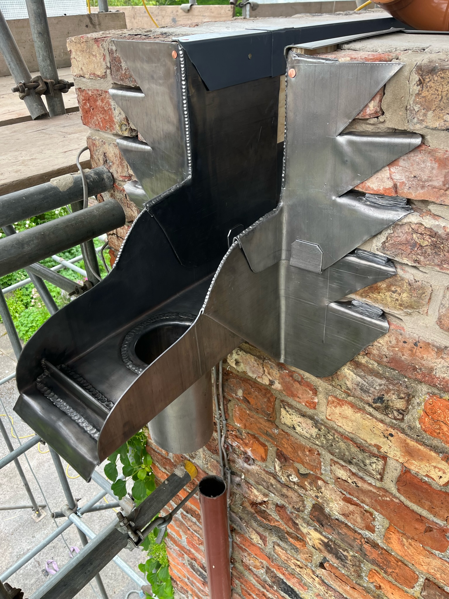 Detailed outlet with welded spigot and overflow weir formed from a lead lined gutter using code 6 lead
